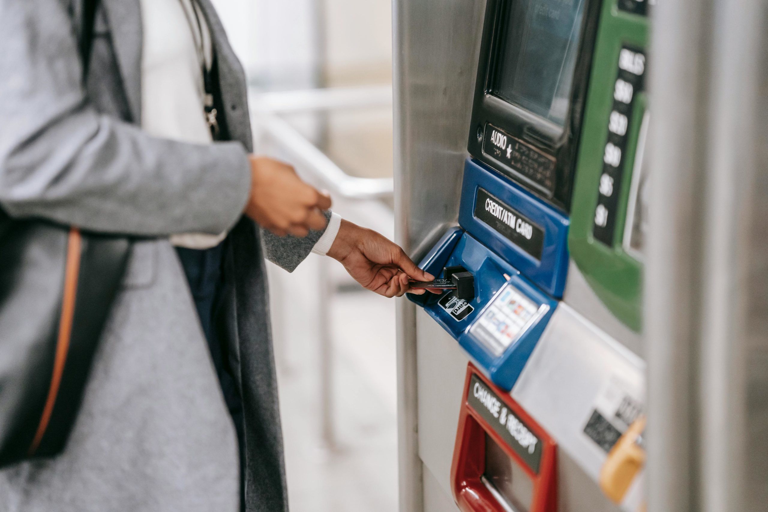 Mann In Der Schwarzen Anzugjacke, Die Blaue Und Schwarze Atm Maschine Hält
