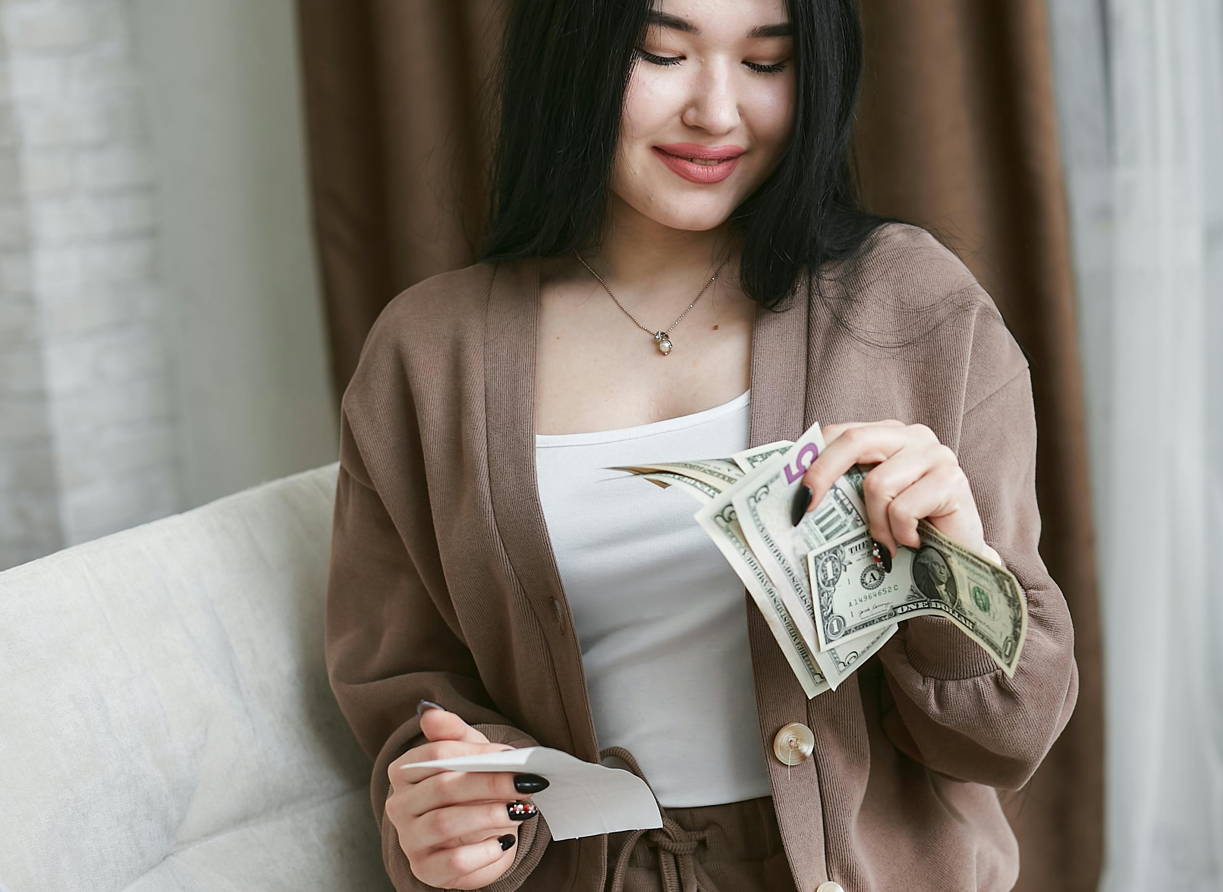 Kostenloses Stock Foto zu asiatische frau, banknoten, festhalten