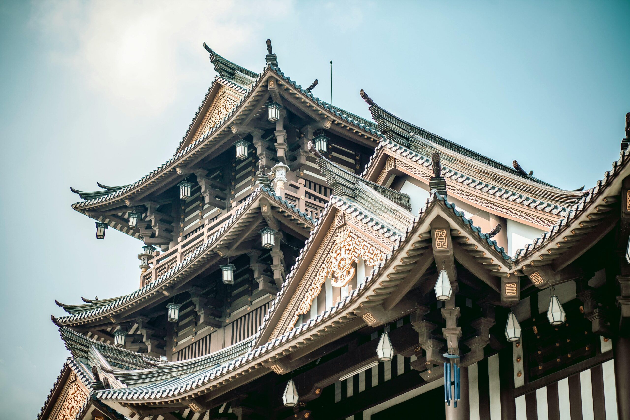 Nahaufnahme eines verzierten Dachs eines traditionellen japanischen Tempels mit komplizierten Details und leuchtenden Farben.