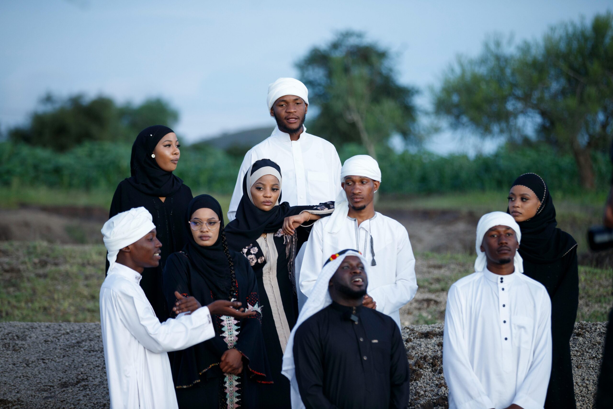 Eine bunt gemischte Gruppe von Erwachsenen in traditioneller Kleidung versammelte sich im Freien und brachte so ihre Einheit und ihr kulturelles Erbe zum Ausdruck.