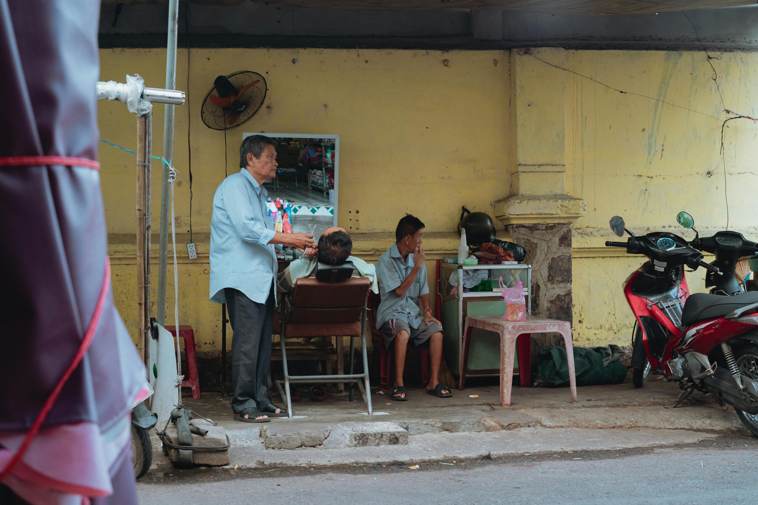 Traditioneller Freiluftfriseur in Bình Thuáºn, der das alltägliche Leben auf den Straßen Vietnams einfängt.