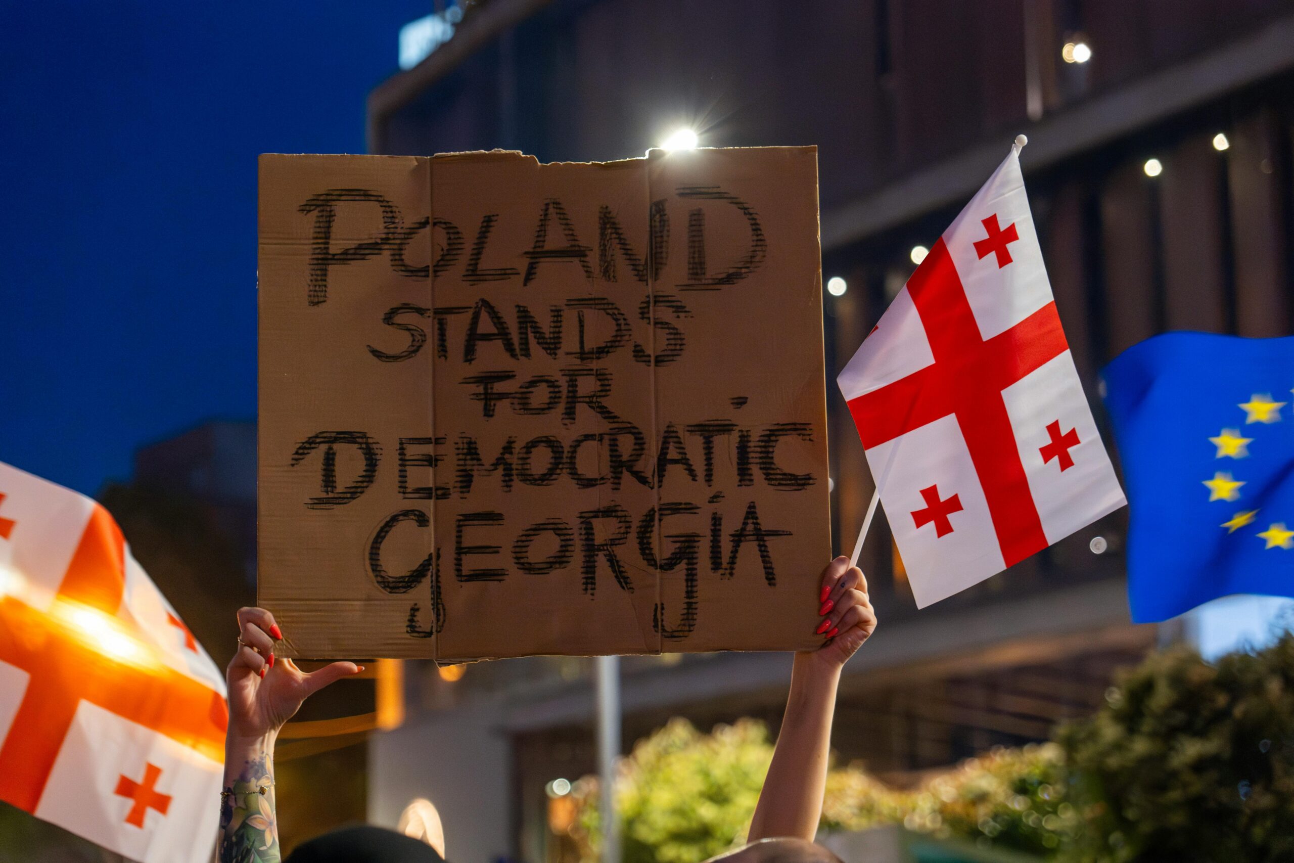 Nächtlicher Protest in Tiflis zur Unterstützung der georgischen Demokratie mit Fahnen und Schildern.